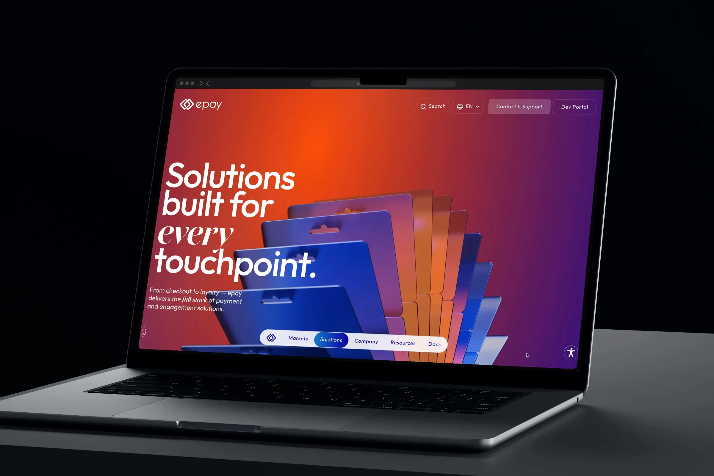 Laptop on a dark desk showing “Solutions built for every touchpoint.”