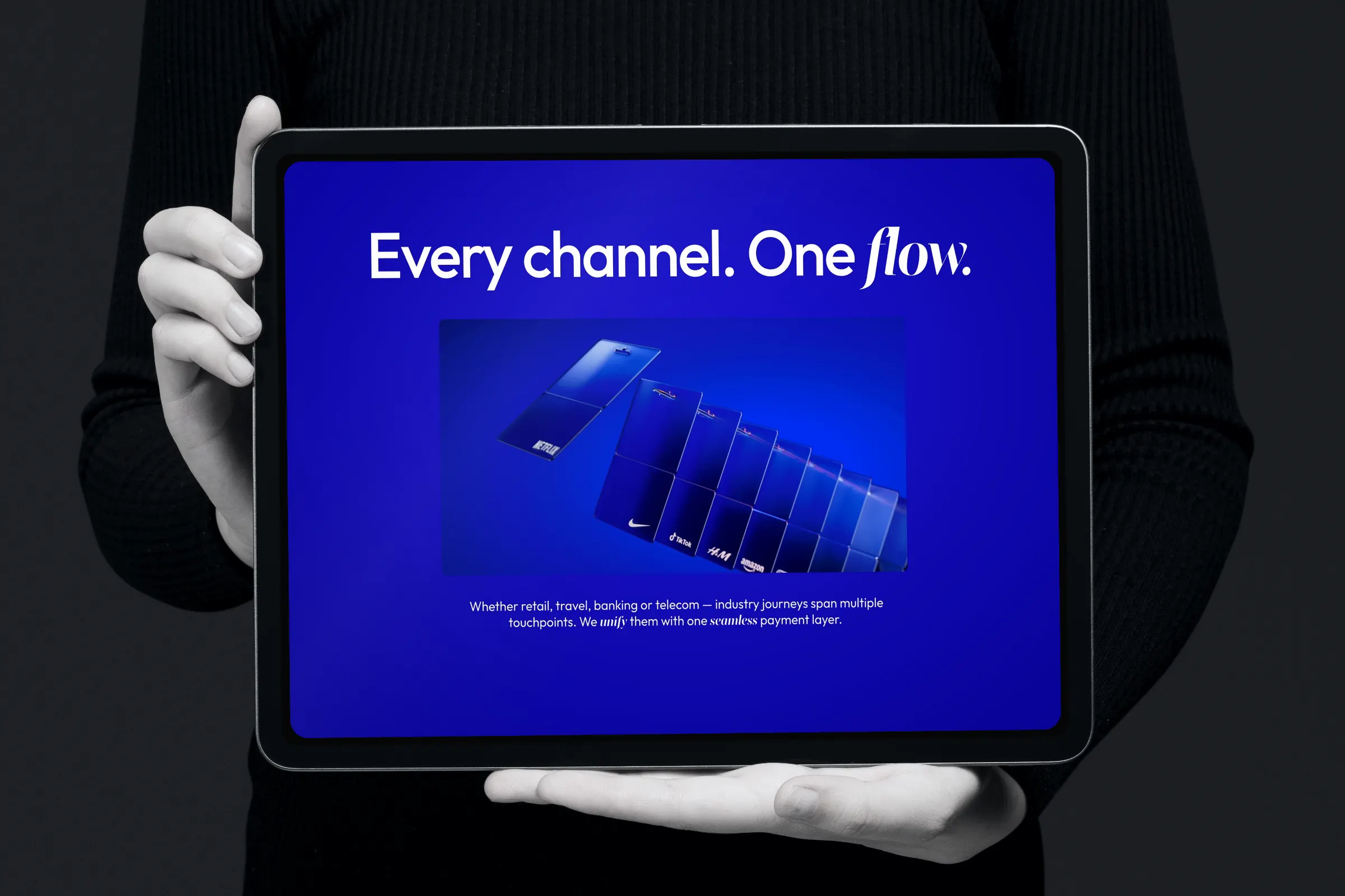 Tablet held in two hands showing “Every channel. One flow.”