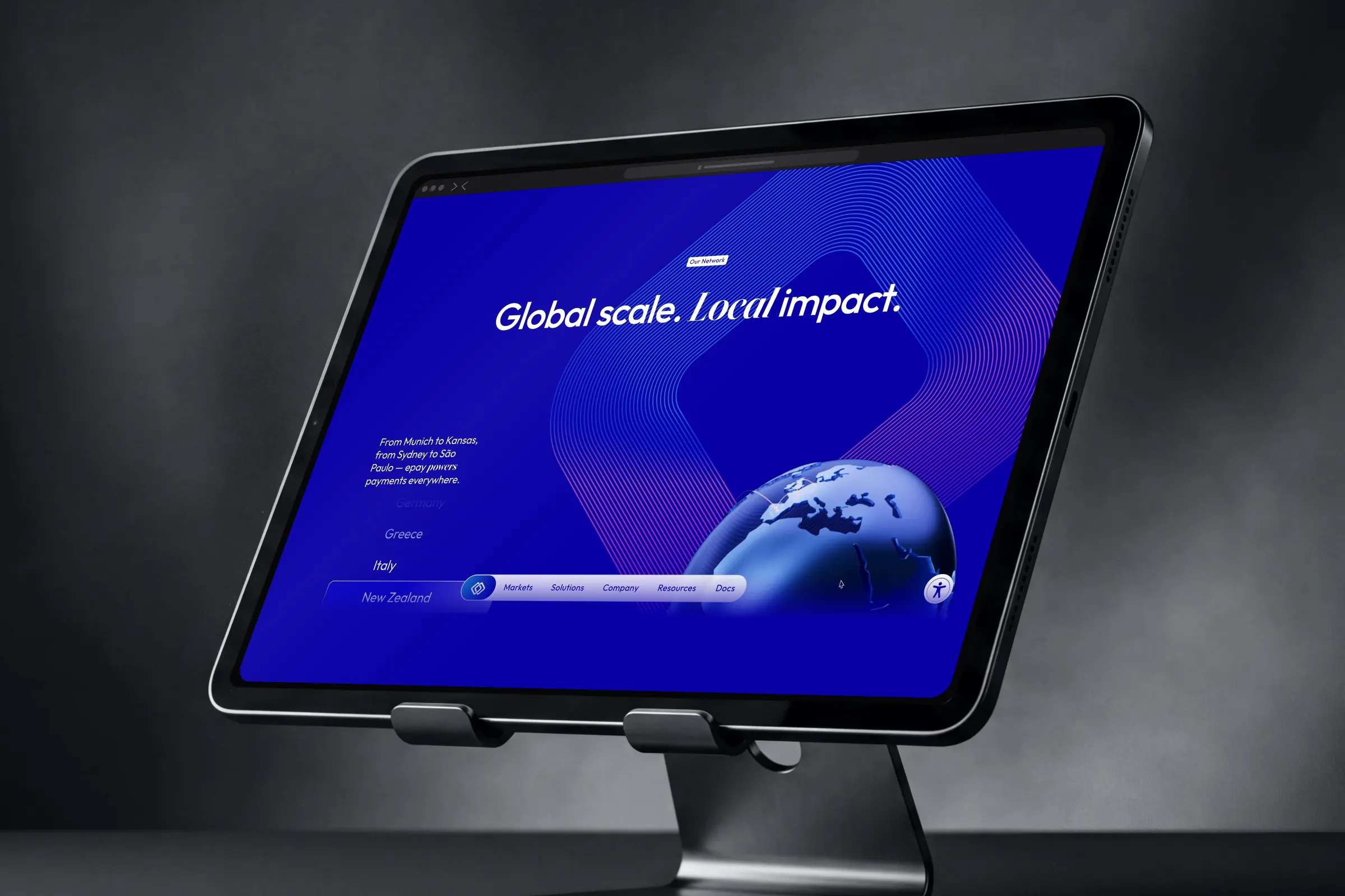 Tablet on a stand showing “Global scale. Local impact.” with a globe