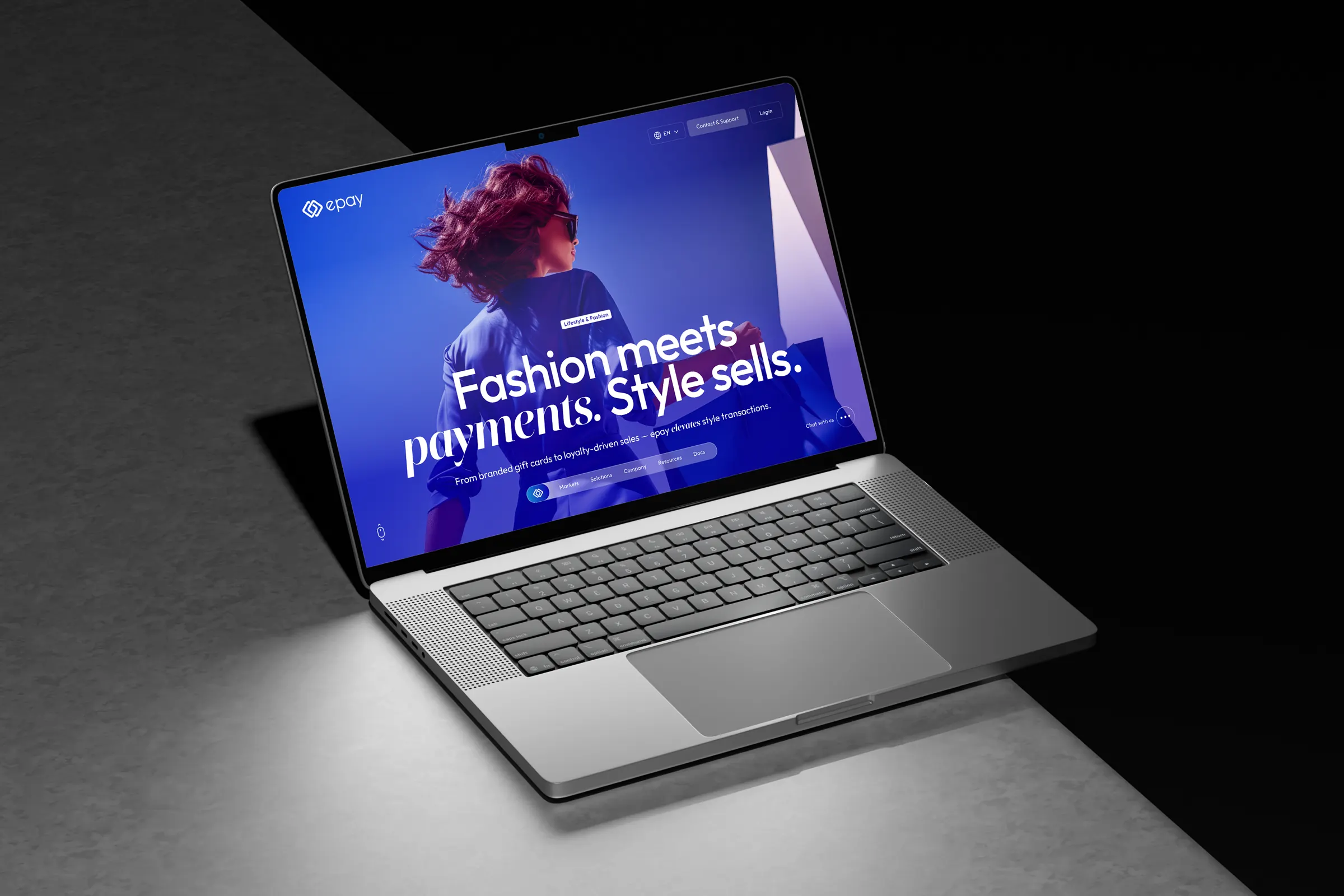 Laptop on a concrete ledge showing “Fashion meets payments. Style sells.”