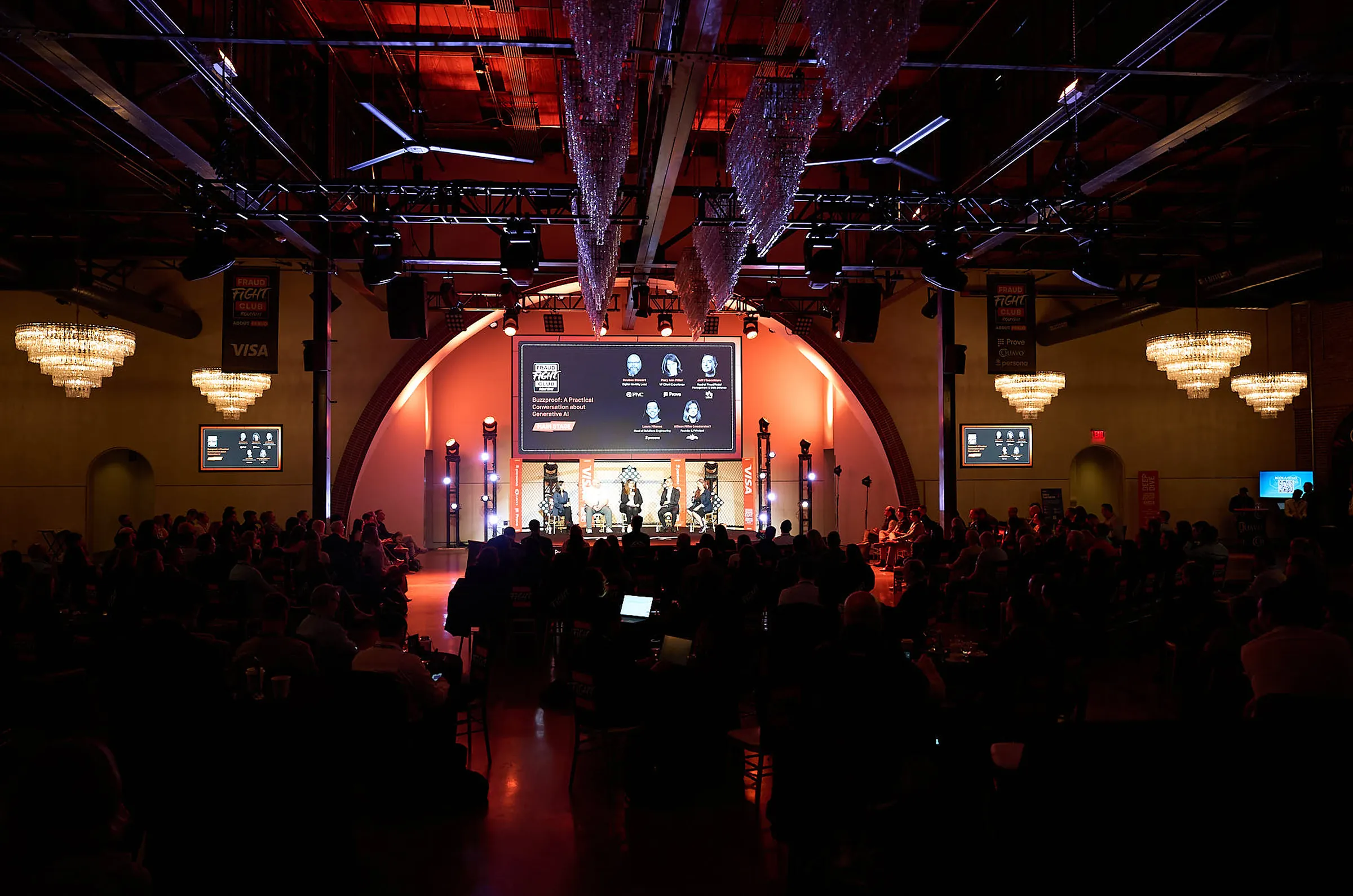 Round III at The Revelry: a panel on the octagon stage under the club’s screen, the full room in the dark below crystal chandeliers