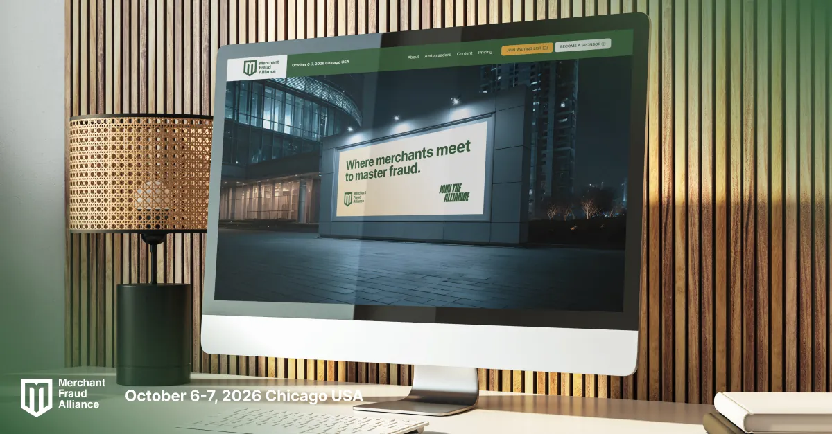 Desktop computer in a wood-panelled room showing the event website: “Where merchants meet to master fraud.”