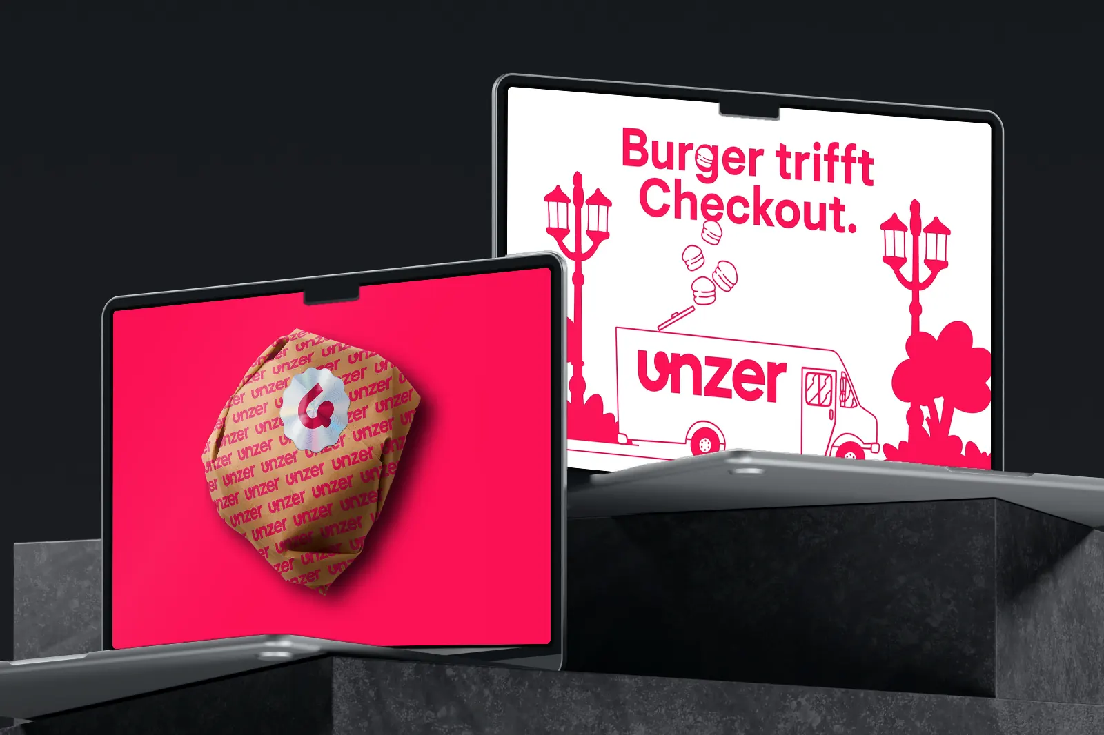 Two laptops on a stone plinth: the comic film of the Unzer Burger Tour on the back one, the pitch deck “Food meets Payment Experience.” on the front one