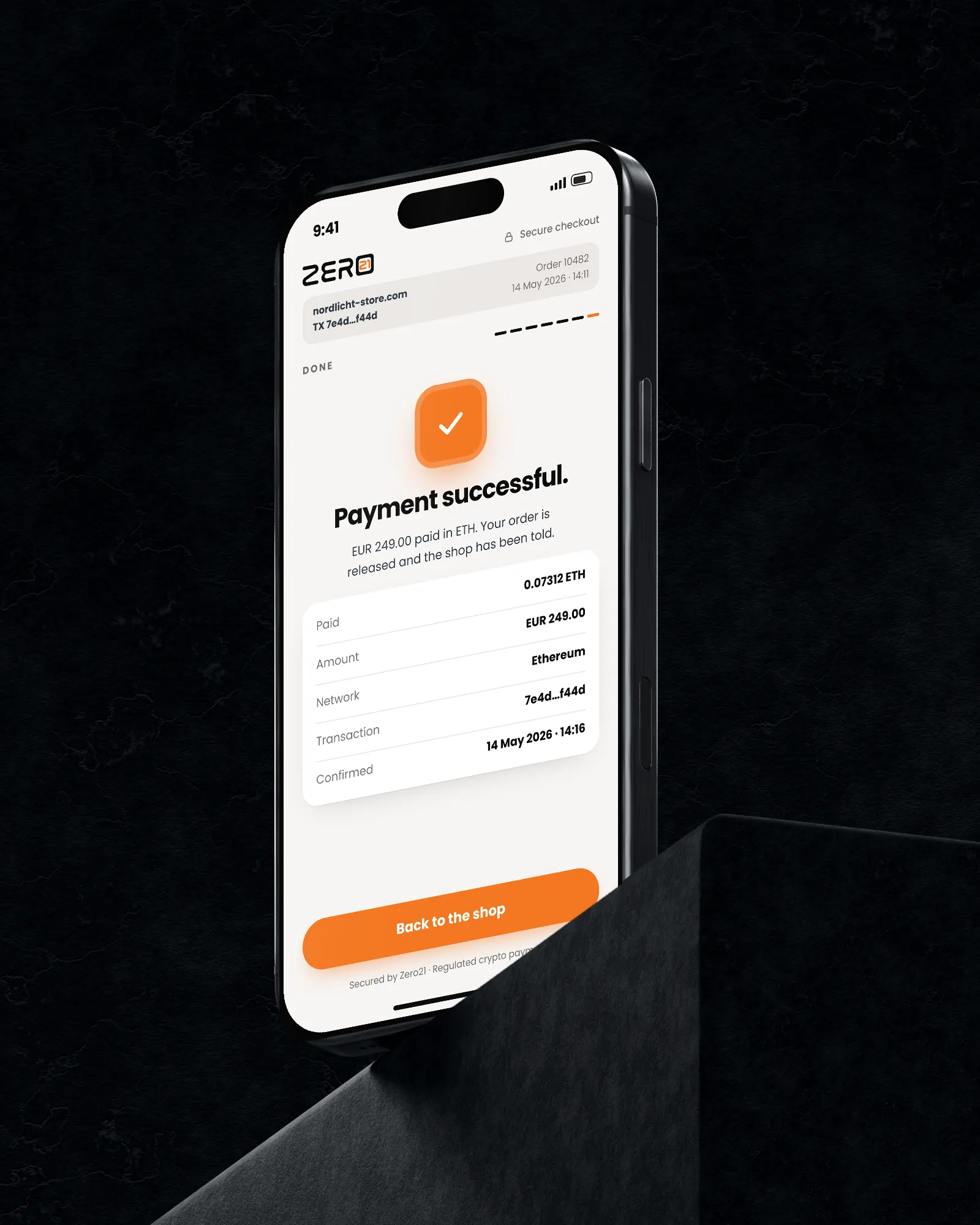 Phone on a block showing “Transaction Successful!” on orange