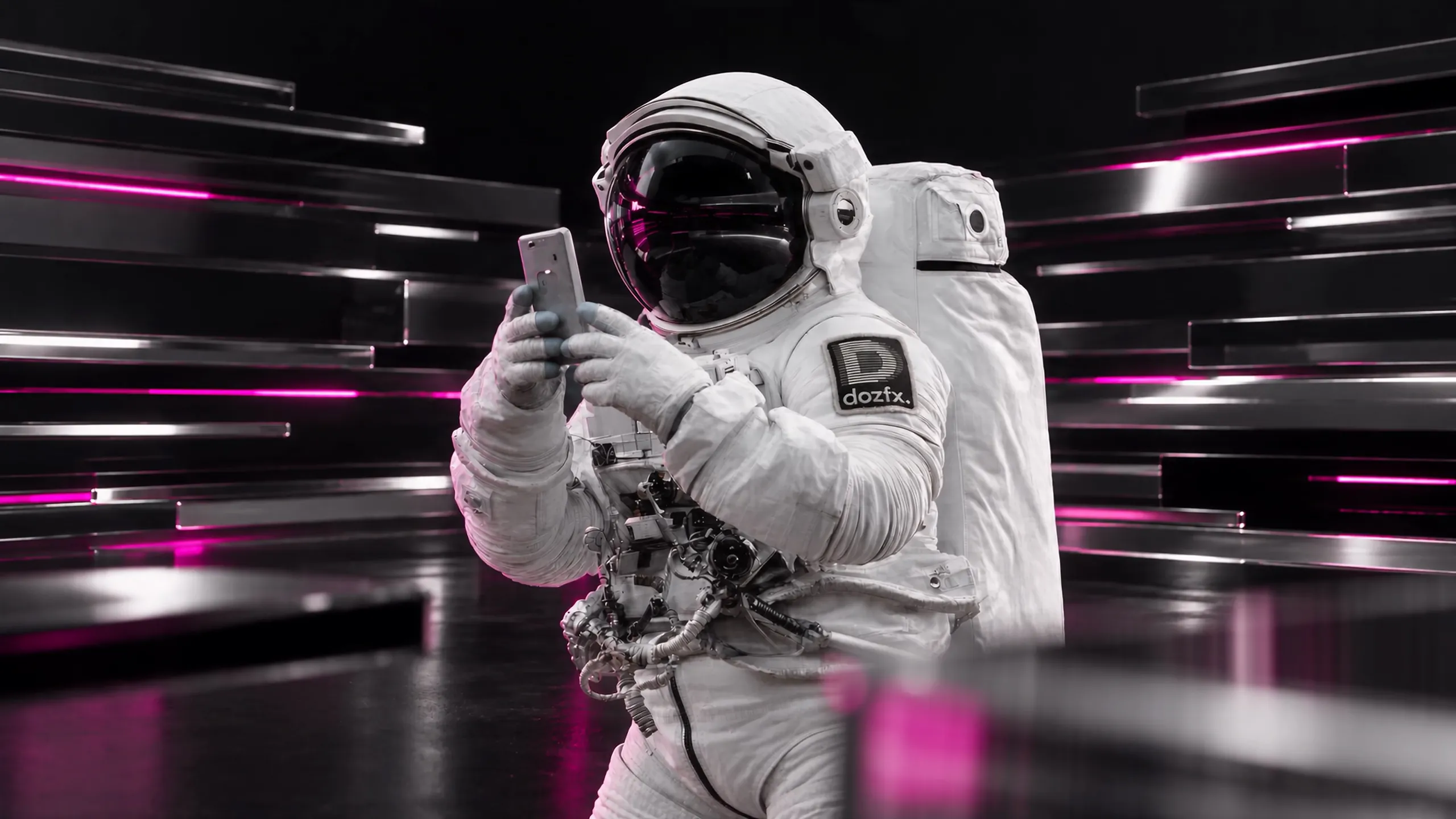 The dozfx astronaut in a white suit with the striped-D patch lowers a phone and turns toward you, between dark glass slats with magenta light