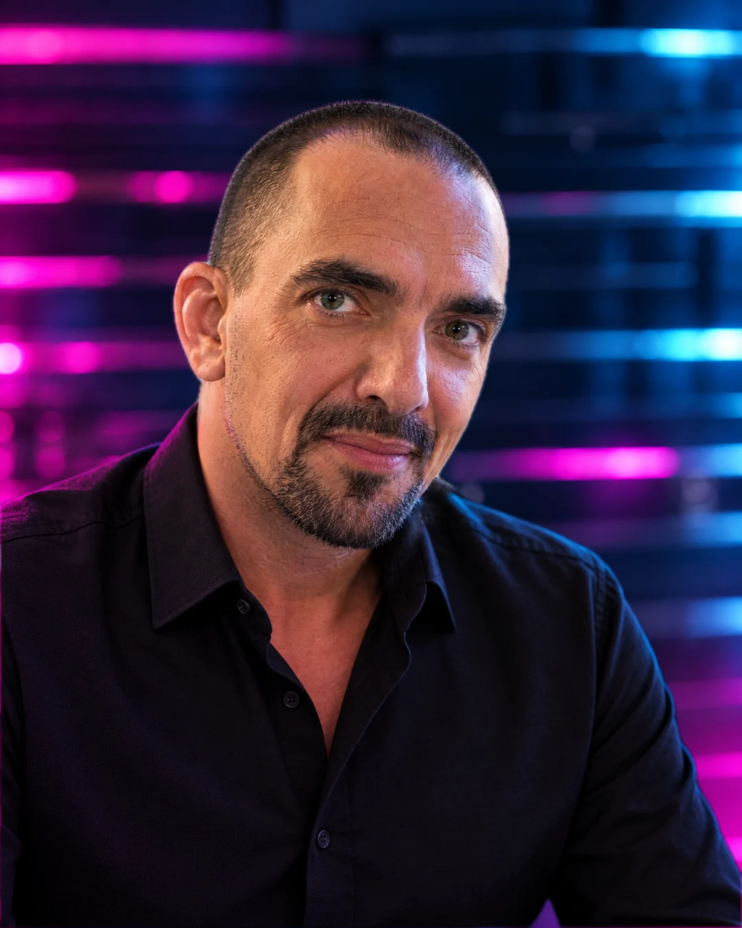 Thomas ‘Joe’ Hahn, founder of dozfx, in a black shirt in front of magenta and blue light lines